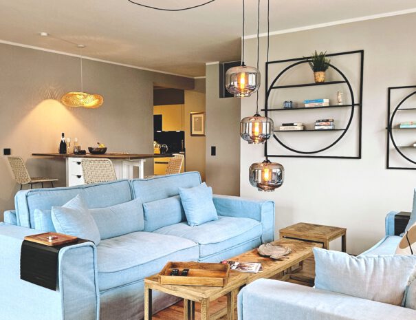 Wohnzimmer mit hellblauer Couch und stylischen Lampen im Loft-Stil